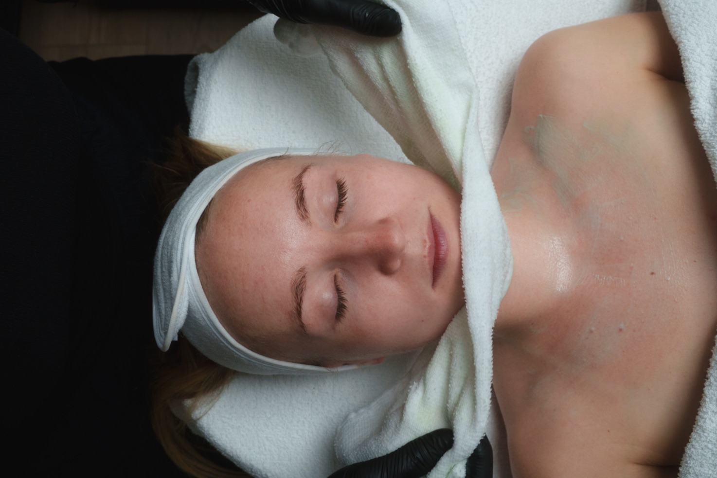 Frau im Spiegel bei der Gua-Sha-Anwendung